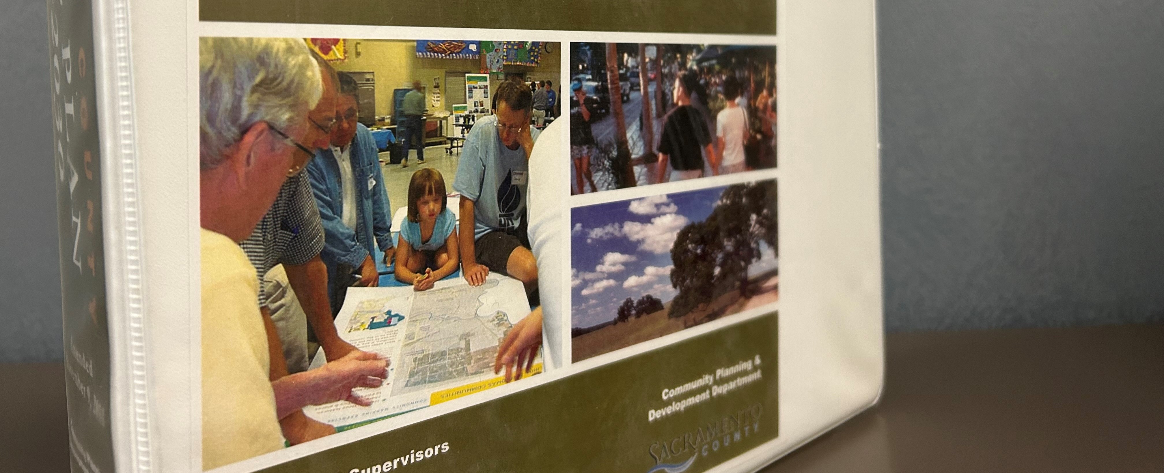 People looking at a drawing on a table